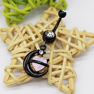 Black moon belly ring with pink heart gem and clear crystal on a woven star background
