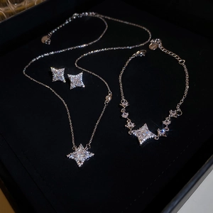 Elegant silver star jewelry set including necklace, bracelet and earrings on velvet box