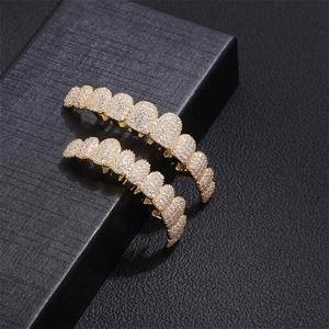 Macro shot of gold-plated hip hop grillz set with sparkling cubic zirconia on black box