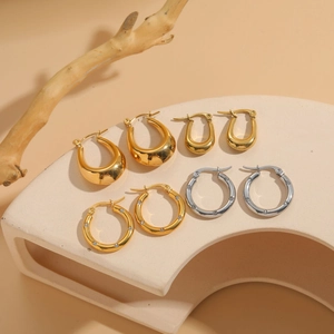 Exaggerated titanium steel gold hoops and zircon earrings set on aesthetic minimalist props