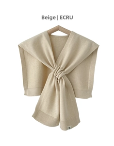 Detailed view of beige knit faux collar shawl draped on a wooden hanger with rib edges