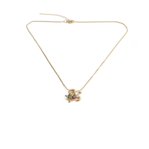 Macro shot of gold turtle pendant necklace set with colorful faceted crystals