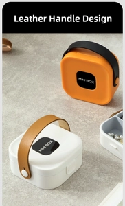 Detail of portable mini box showing leather handle design and compartmentalized storage