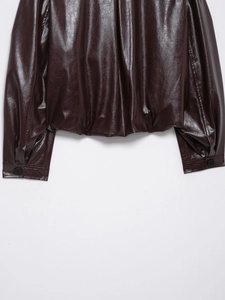 Close-up of the hem and cuffs on this burgundy faux leather bomber jacket for women
