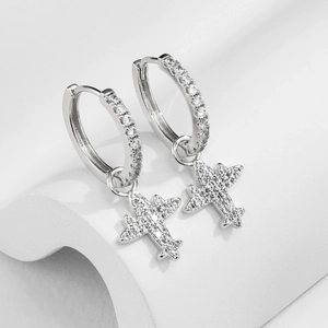 Detail of silver airplane earrings featuring micro-pave cubic zirconia on white background