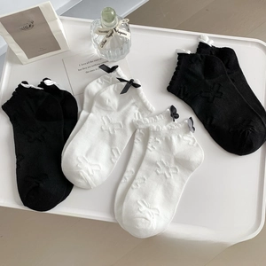 Detailed view of four pairs of sweet Lolita socks with bow accents and butterfly patterns