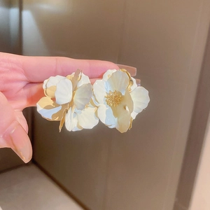 Detail showing the intricate 3D floral petals and golden core of the elegant earrings