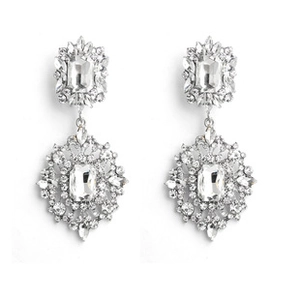 Macro detail of silver-tone drop earrings featuring zircon stones and pearl teardrops