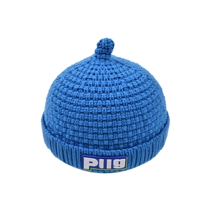 Close-up of chunky knit blue beanie with Plig logo patch and rolled edge detail