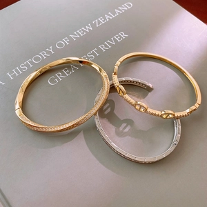 Macro shot of gold and silver plated bangle set with cubic zirconia on a book background