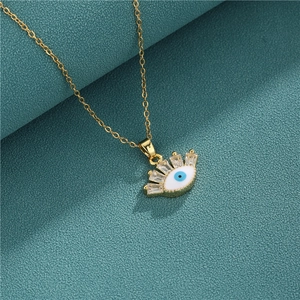 Gold evil eye necklace with white enamel, blue center eye, and zircon crystals