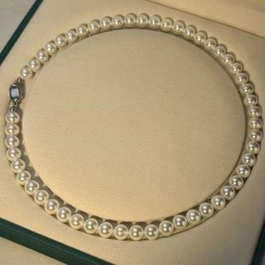 Macro shot of 6-7mm round white freshwater pearl necklace on a velvet jewelry box display