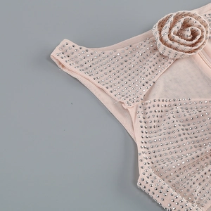 Détail de la robe moulante rose clair avec fleurs 3D et strass argentés scintillants