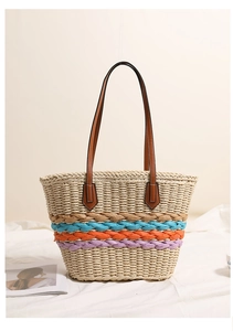 Detail showing rainbow striped weaving texture and brown PU leather straps of straw tote bag