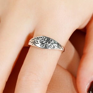 Macro view of vintage silver ring featuring engraved leaf patterns and oxidized finish