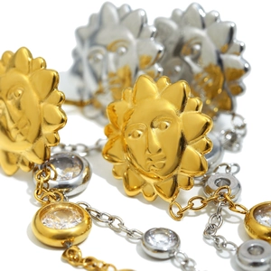 Détail macro d'un relief soleil plaqué or 18K avec zircons clairs sur boucle d'oreille