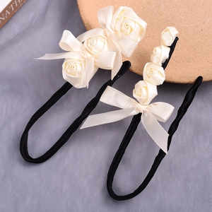 Close-up detail of vintage cream satin rose hair bun makers featuring elegant ribbon bows