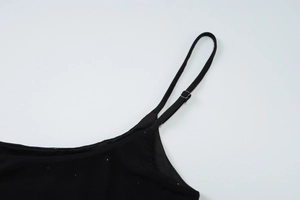 Détail des fines bretelles réglables sur une robe noire sexy en maille fine