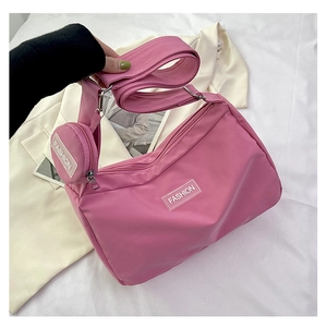 Pink nylon tote bag detail with matching circular coin purse and fashion logo tag