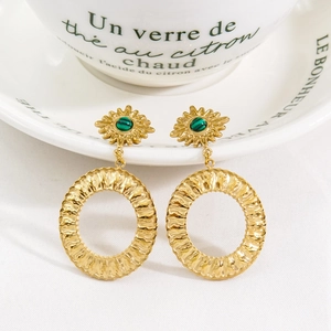 Detail of bohemian gold drop earrings with sunflower studs and green malachite beads