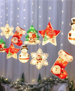 Detail of warm white LED Christmas curtain lights with snowflake and star pendants