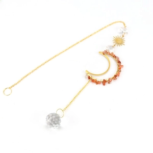 Detail of suncatcher with golden moon frame, orange stones, and clear crystal ball charm