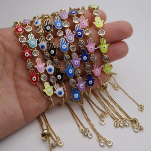 Detail of adjustable Hamsa hand bracelets with colorful enamel evil eye charms