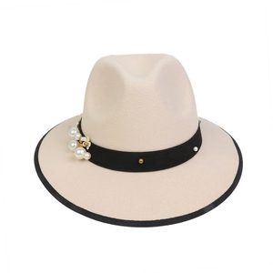 Detail of cream fedora hat with black band, faux pearls and gold studs decoration