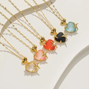 Detailed view of five gold-toned heart necklaces with multi-color stone pendants