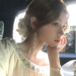 Close-up of white flower chiffon tassel earrings with pearls on a model in natural light