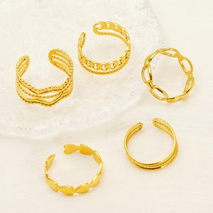 Set of five gold-toned open chain rings displayed on a textured glass tray