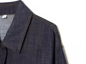 Detailed close-up of dark blue denim dress collar with classic orange double stitching