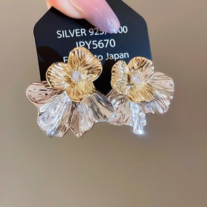 Nahaufnahme der zweifarbigen Blumenohrringe mit klaren Steinen auf einer 925er Silberkarte