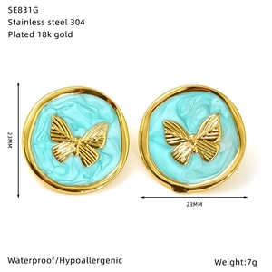 Detail of round butterfly earrings in 18k gold plated steel with turquoise enamel