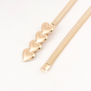 Detail of golden elastic waist belt featuring four linked heart-shaped metal buckles