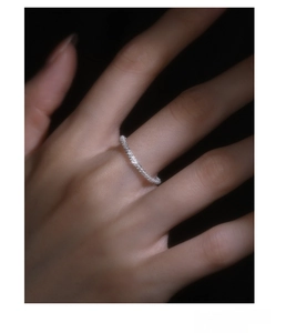 Macro shot of S925 sterling silver ring with shimmering texture on a dark hand model