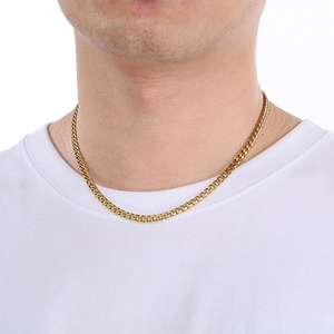 Close-up of polished gold Cuban chain necklace for men on a white t-shirt