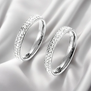 Close-up detail of silver titanium steel rings with crushed diamond effect on white satin