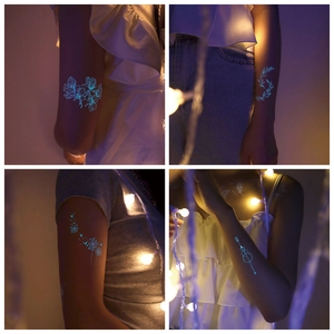 Tatuaggi temporanei luminosi con mandala e farfalle bianche che brillano di blu al buio