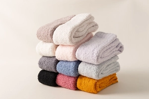 Stacked variety of thick coral fleece knee-high socks in multiple soft colors for winter