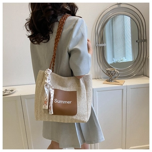 Détail du sac cabas tissé avec poche en cuir marron et accessoire foulard en soie