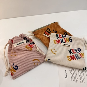 Tre sacchetti in velluto a coste con coulisse in rosa, caramello e beige per oggetti