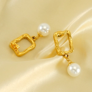 Square hammered gold pearl drop earrings on champagne silk background