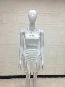 Dettaglio di un completo bianco due pezzi con crop top e minigonna con frange sexy