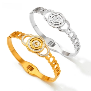 Detail of silver and gold stainless steel bangles with Roman numerals and crystals