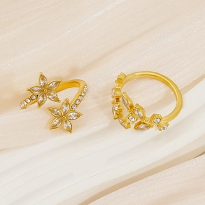 Macro shot of gold floral rings with marquee marquise zirconias on silk fabric