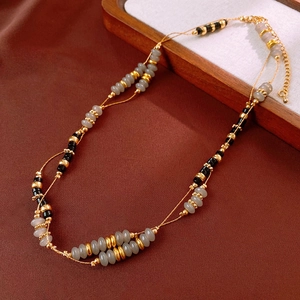 Detail of double-layer agate beaded necklace with gold spacers and lobster clasp