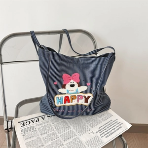 Detail of blue striped canvas tote with plush puppy embroidery and HAPPY lettering