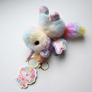 Detail of colorful plush unicorn keychain with shimmering sequins and gold metal clasp