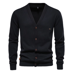 Detail of black knit cardigan showing V-neck, brown buttons and small metal badge